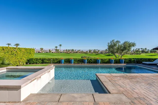 a view of swimming pool with outdoor seating and plants