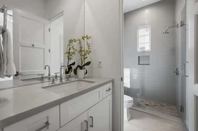 a bathroom with a sink a toilet a large mirror and shower