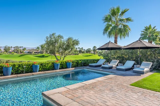 a view of a patio with couches and table with wooden floor and fence