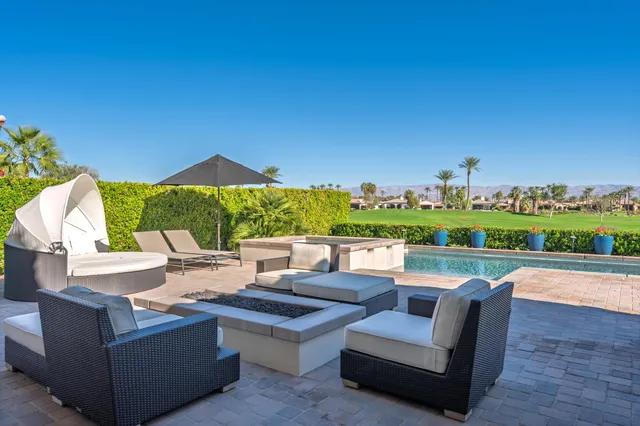 a swimming pool with outdoor seating and yard