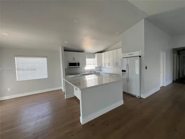 a view of kitchen with stainless steel appliances cabinets and wooden floor