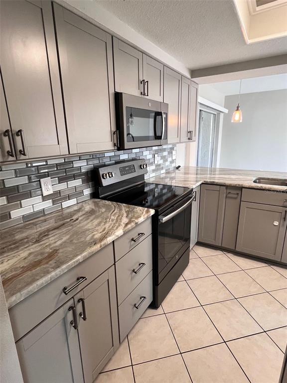 4317 Chipmunk Drive New Port Richey, FL 34653 - Photo 5 of 23 a kitchen with stainless steel appliances granite countertop a sink and white cabinets