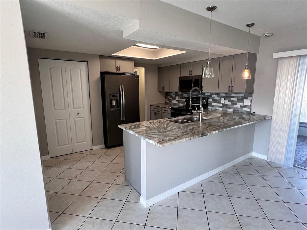 4317 Chipmunk Drive New Port Richey, FL 34653 - Photo 7 of 23 a kitchen with stainless steel appliances granite countertop a refrigerator and a sink