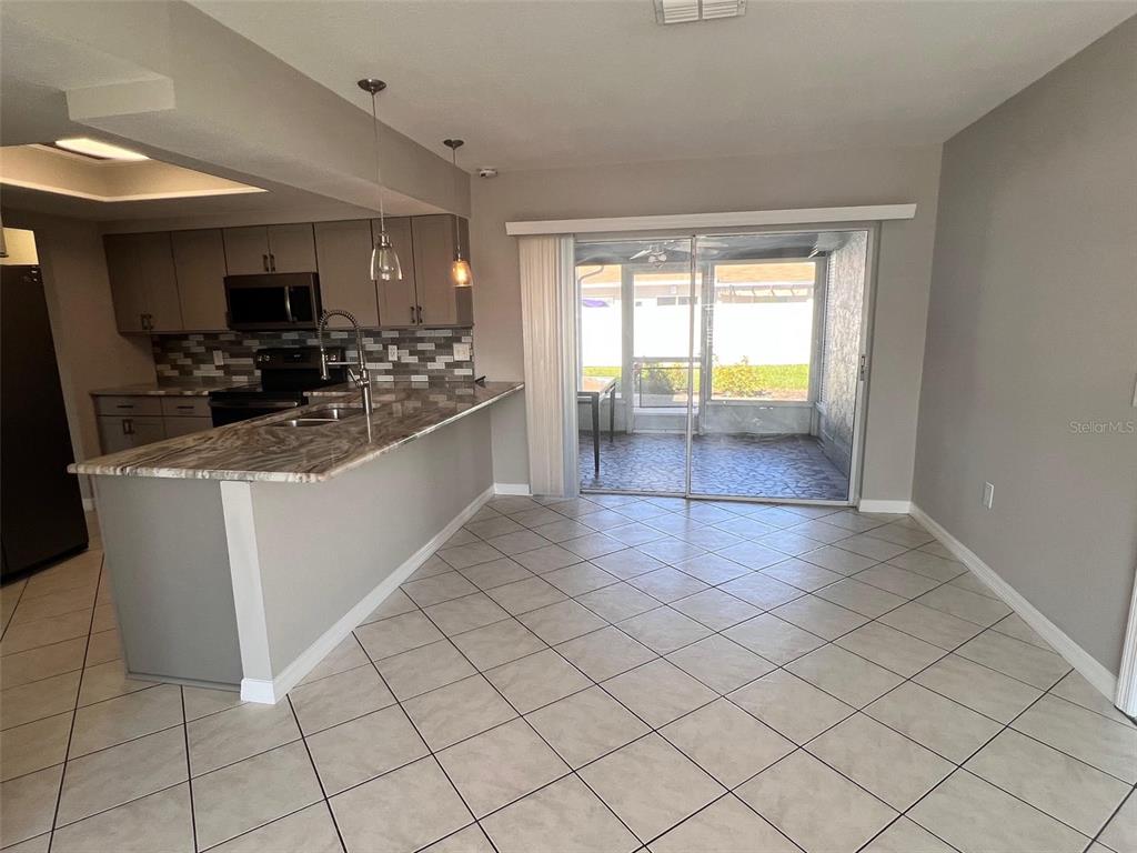 4317 Chipmunk Drive New Port Richey, FL 34653 - Photo 8 of 23 a kitchen with stainless steel appliances a sink stove and cabinets