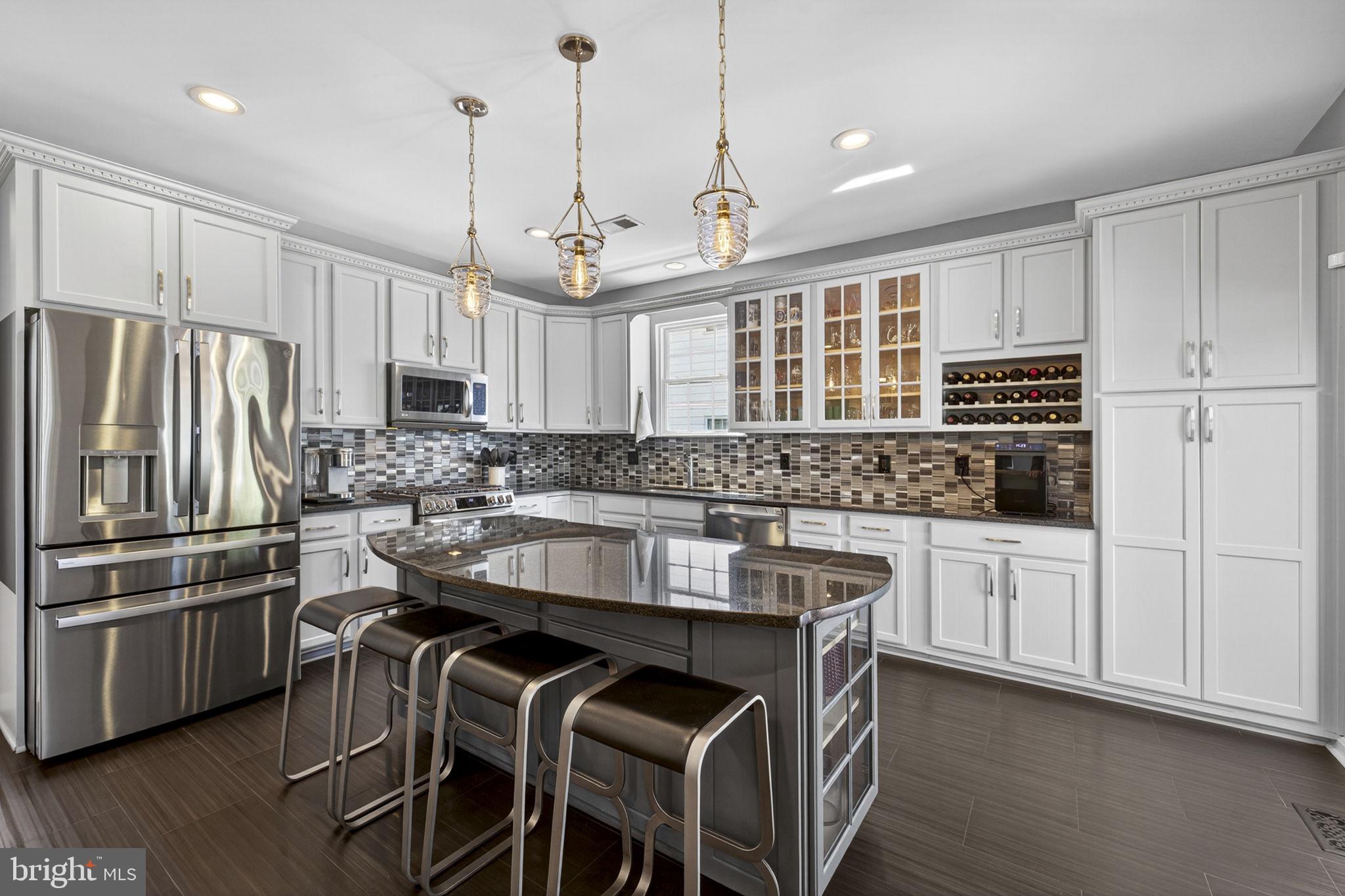 43200 Lighthouse Place Chantilly, VA 20152 - Photo 14 of 47 a kitchen with kitchen island granite countertop a stove a sink a center island and wooden floor