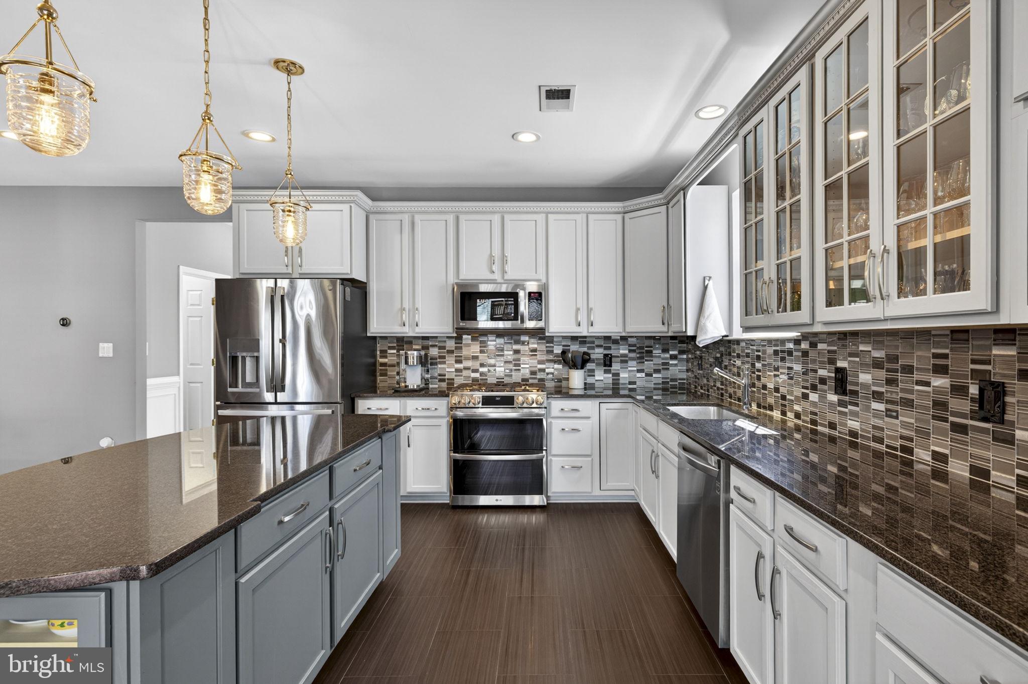 43200 Lighthouse Place Chantilly, VA 20152 - Photo 15 of 47 a kitchen with kitchen island granite countertop a sink stainless steel appliances and cabinets