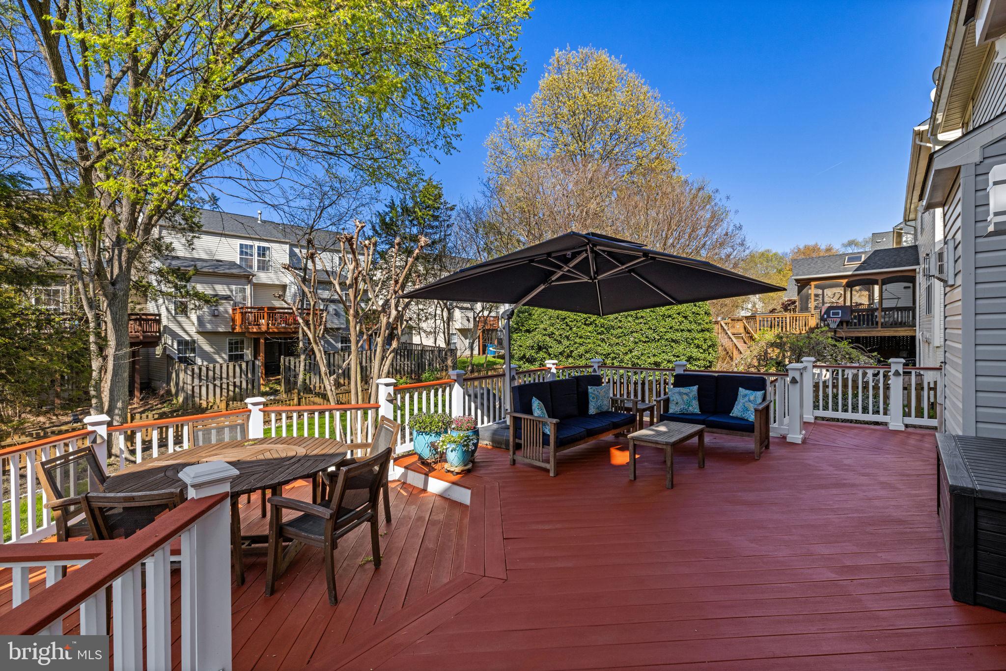 43200 Lighthouse Place Chantilly, VA 20152 - Photo 39 of 47 a view of a patio with a table and chairs under an umbrella with wooden fence