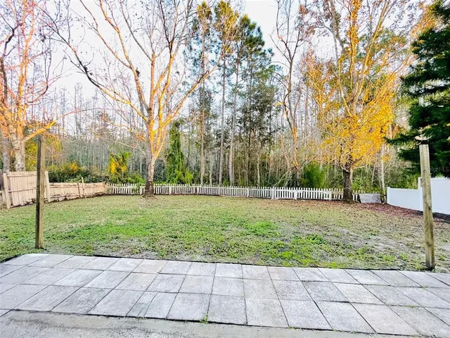 a view of backyard with swimming pool and green space