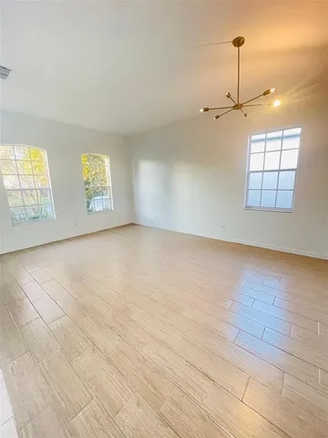 an empty room with windows and cabinet