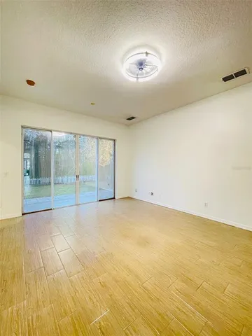 en empty room with wooden floor and windows