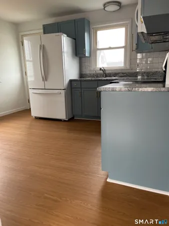 a kitchen with granite countertop a refrigerator and a sink