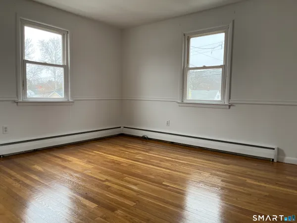 a view of a room with wooden floor and window