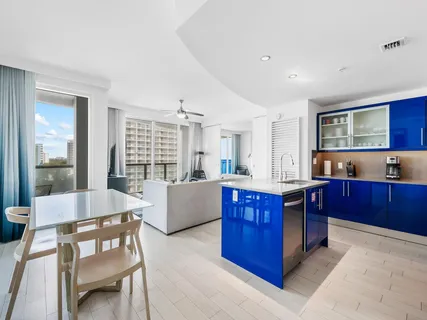 a large kitchen with stainless steel appliances granite countertop a large counter top and wooden floors