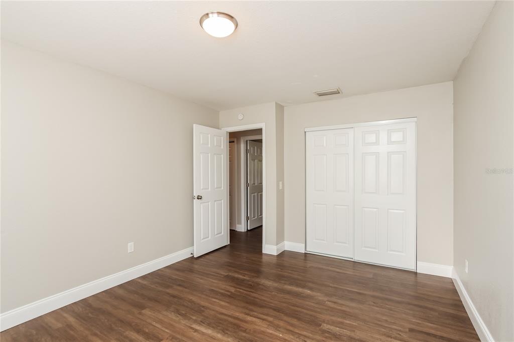 481 Ralwood Lane Northeast Palm Bay, FL 32907 - Photo 12 of 18 a view of an empty room with wooden floor