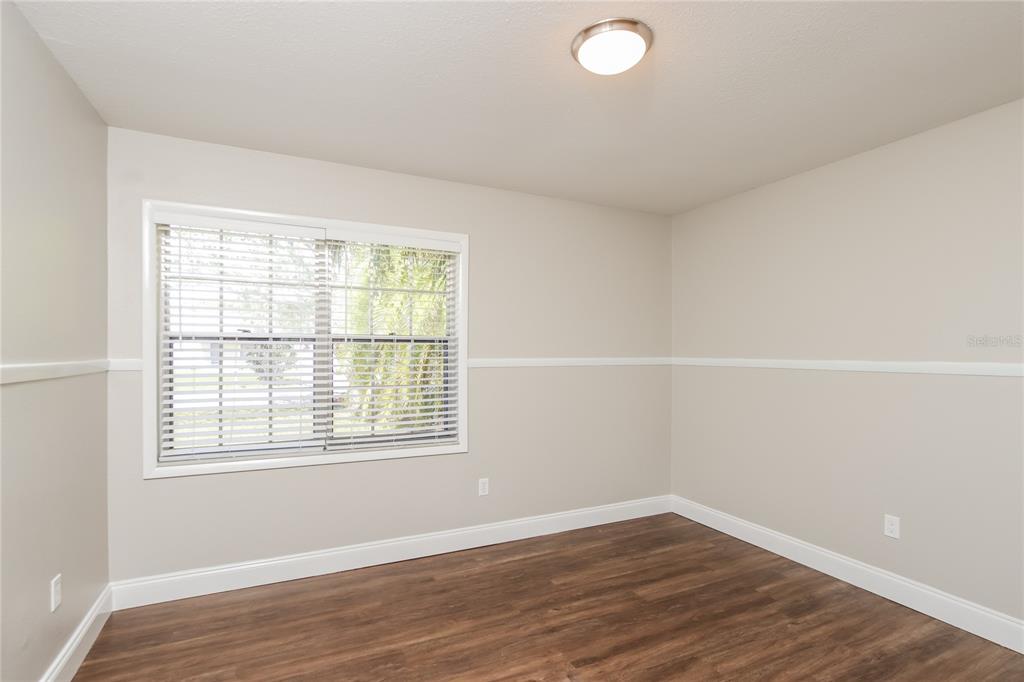 481 Ralwood Lane Northeast Palm Bay, FL 32907 - Photo 14 of 18 an empty room with wooden floor and windows