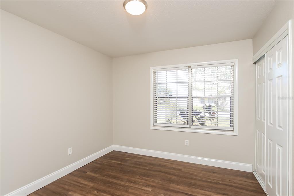 481 Ralwood Lane Northeast Palm Bay, FL 32907 - Photo 16 of 18 an empty room with wooden floor and windows