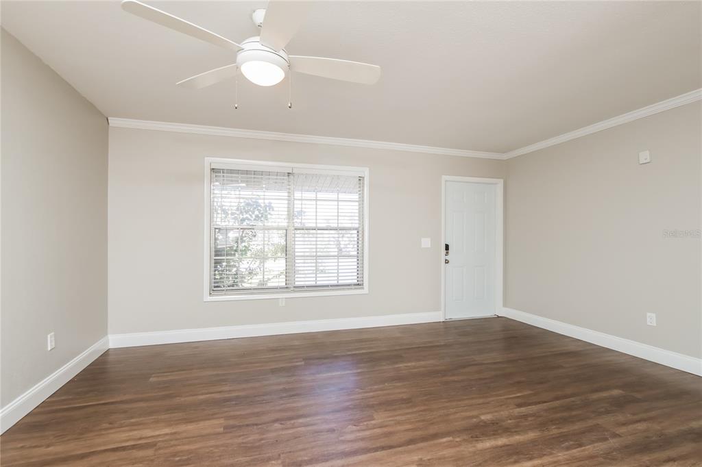 481 Ralwood Lane Northeast Palm Bay, FL 32907 - Photo 4 of 18 an empty room with wooden floor and windows