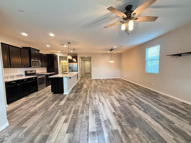 a large kitchen with kitchen island a stove a sink dishwasher a refrigerator with a dining table and chairs