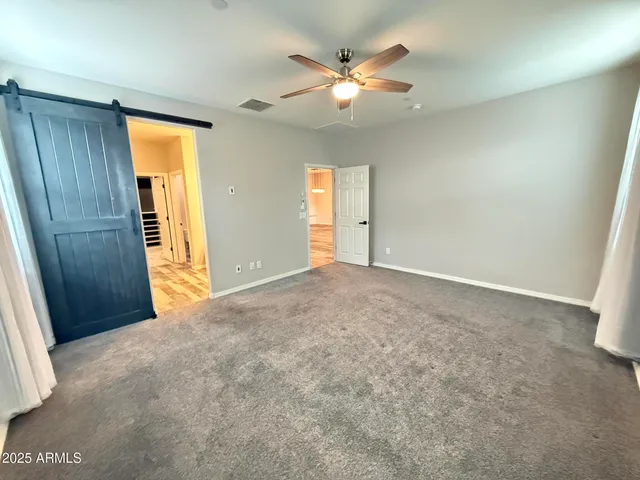 an empty room with closet and fan