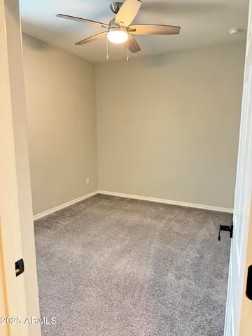 an empty room with a ceiling fan and a window
