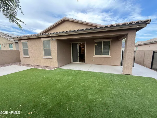 a view of a house with a yard potted plants and a large tree
