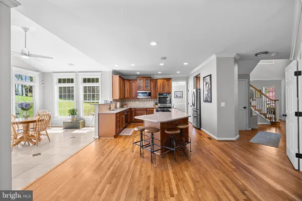 a living room with stainless steel appliances granite countertop furniture wooden floor and a fireplace