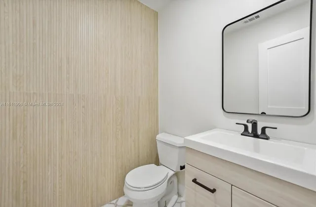 a bathroom with a sink a toilet and mirror
