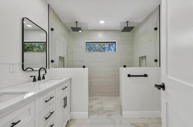 a bathroom with a double vanity sink a mirror and a bathtub