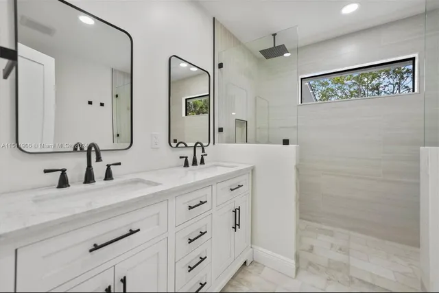 a bathroom with a double vanity sink mirror and shower