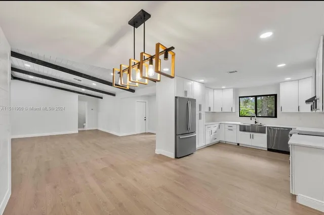 a view of a kitchen with furniture and stainless steel appliances