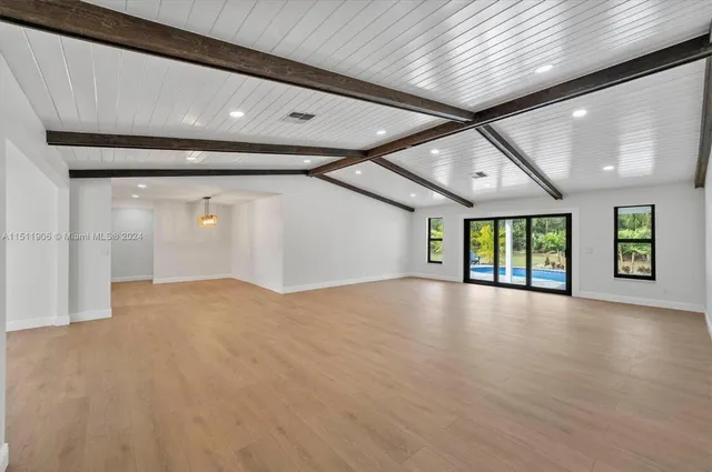 a view of a livingroom with a window and wooden floor