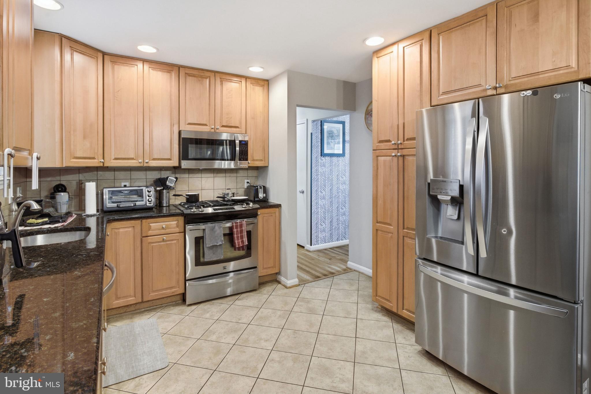 8802 Parliament Drive Springfield, VA 22151 - Photo 9 of 47 Modern kitchen with warm wood cabinetry.