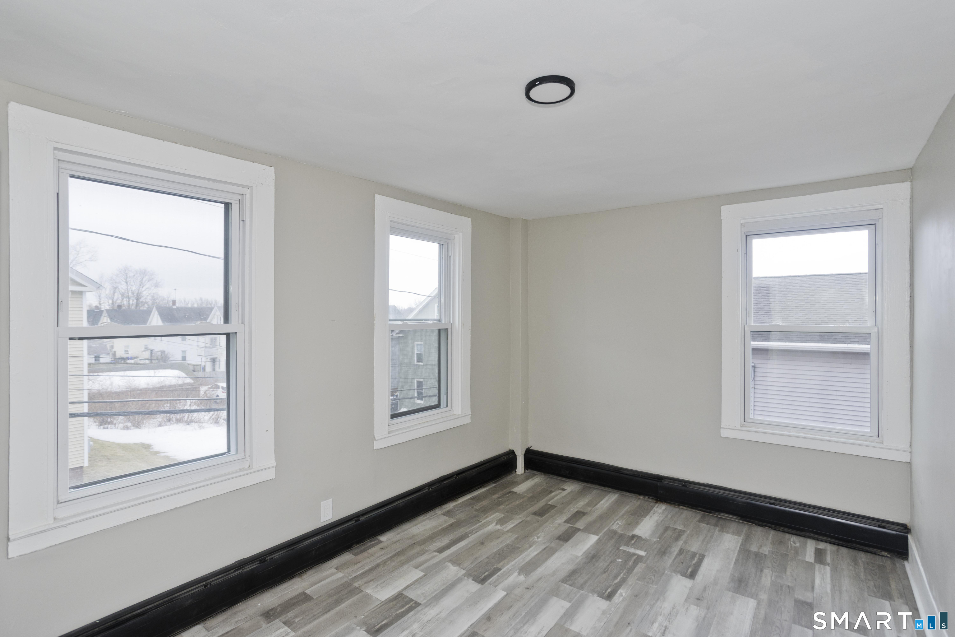 47 Maple Avenue Enfield, CT 06082 - Photo 17 of 36 a view of an empty room with wooden floor and a window