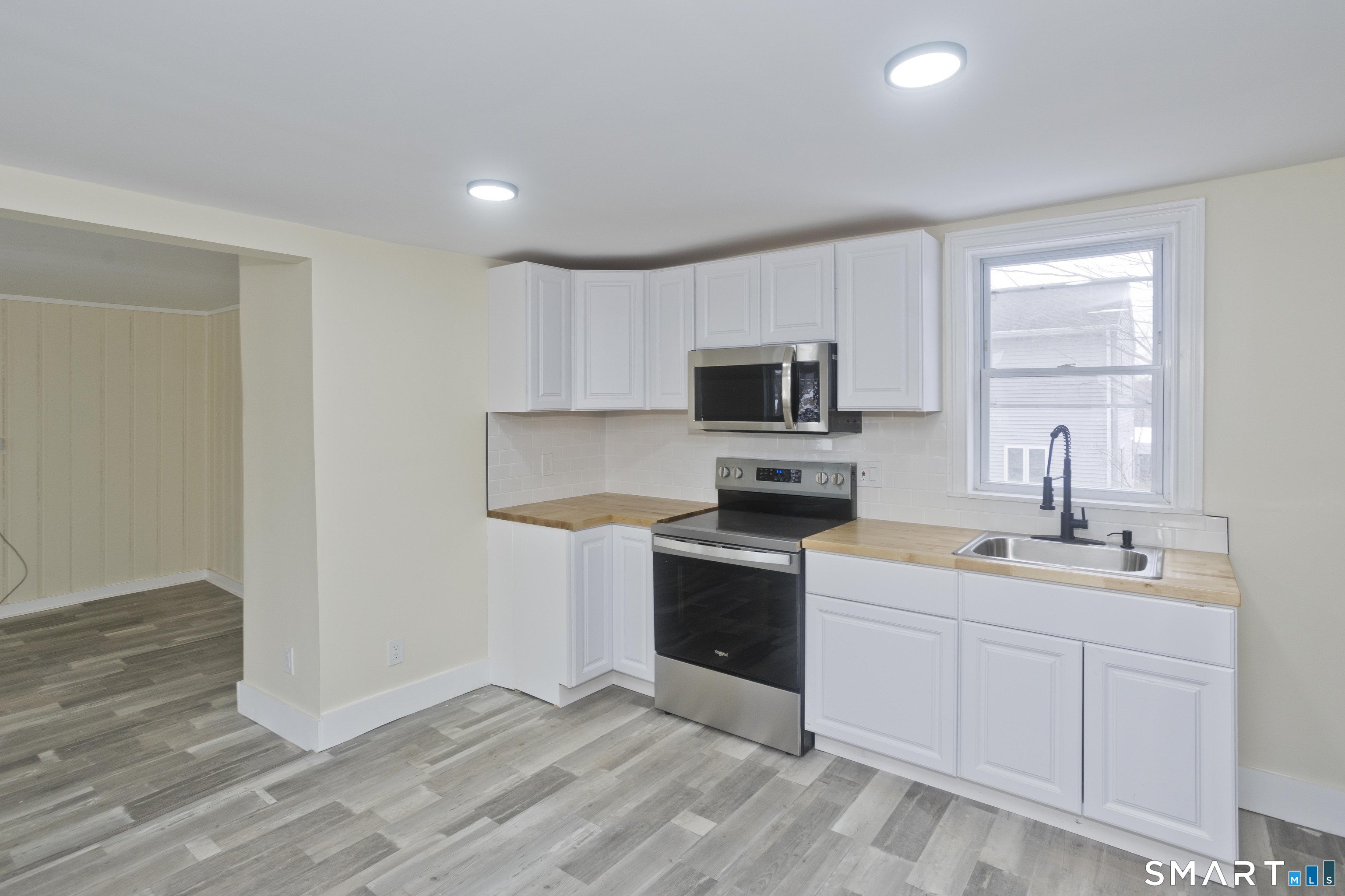 47 Maple Avenue Enfield, CT 06082 - Photo 22 of 37 a kitchen with a sink a stove a microwave and wooden cabinets