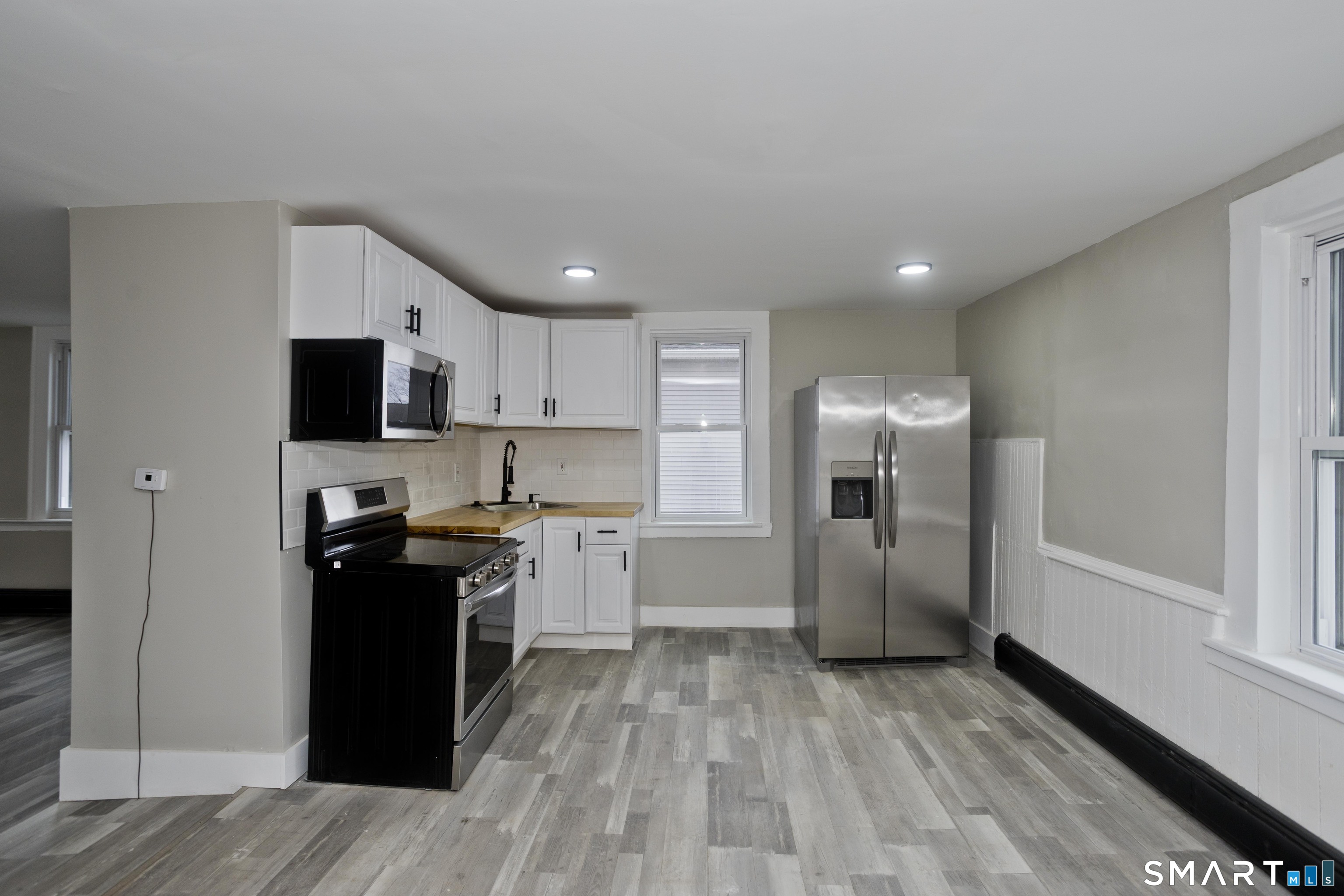47 Maple Avenue Enfield, CT 06082 - Photo 7 of 37 a kitchen with a refrigerator and a stove top oven