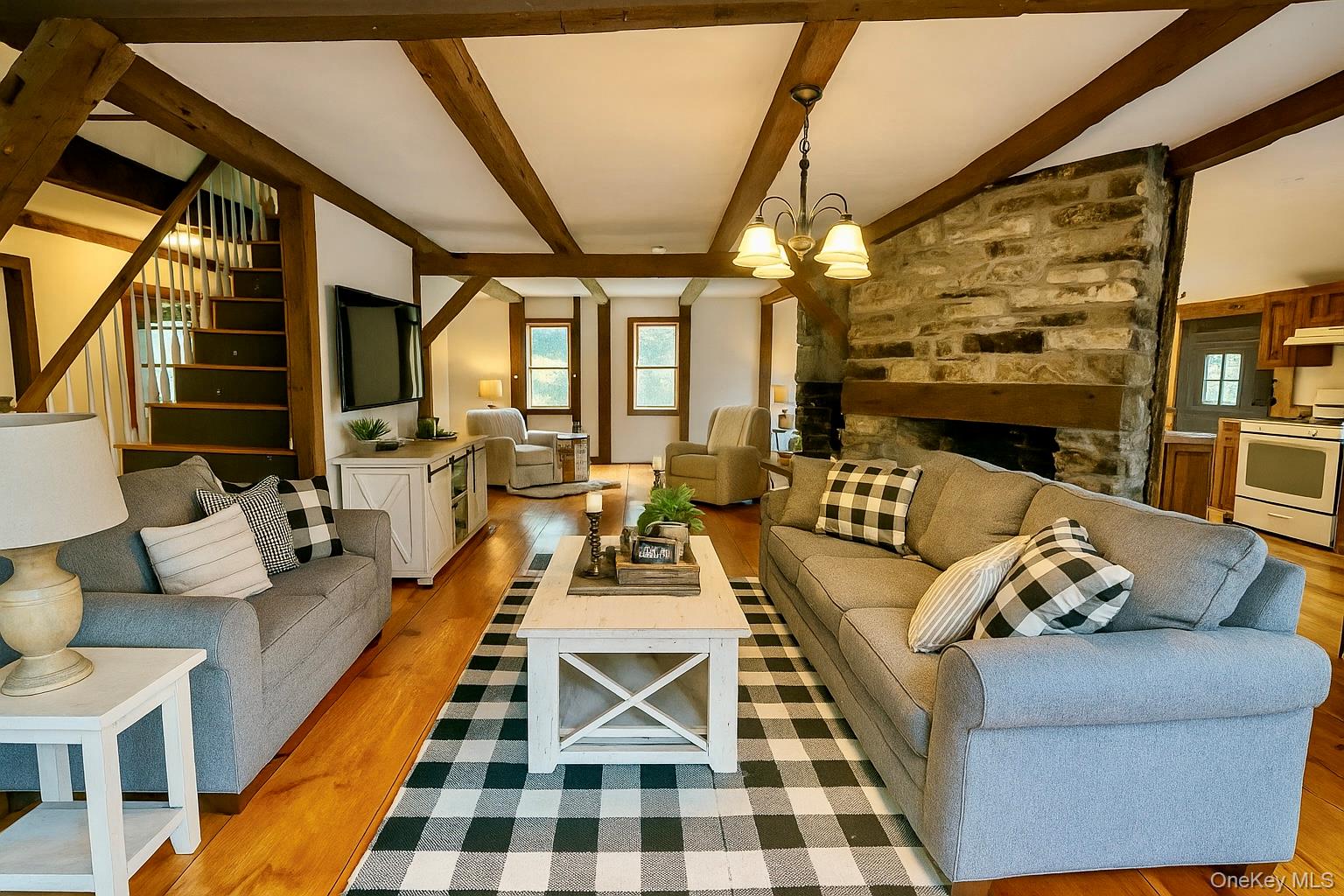 241 White Bridge Road Middletown, NY 10940 - Photo 15 of 29 AI Generated Living room with light wood finished floors, a fireplace, beamed ceiling, stairs, and a chandelier