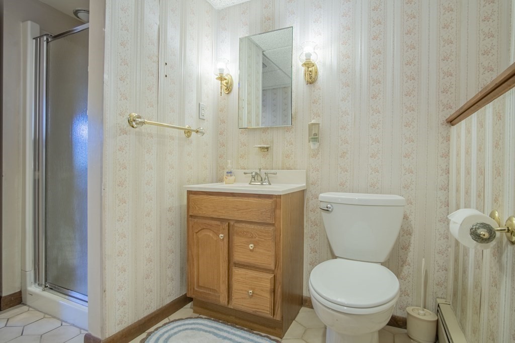 1 Christopher Drive Nahant, MA 01908 - Photo 32 of 41 a bathroom with a granite countertop toilet a sink and a mirror