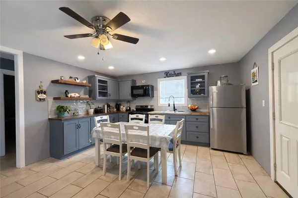a kitchen with a dining table cabinets appliances and a window