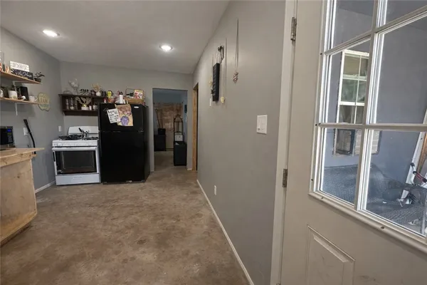 a view of a kitchen with refrigerator and windows