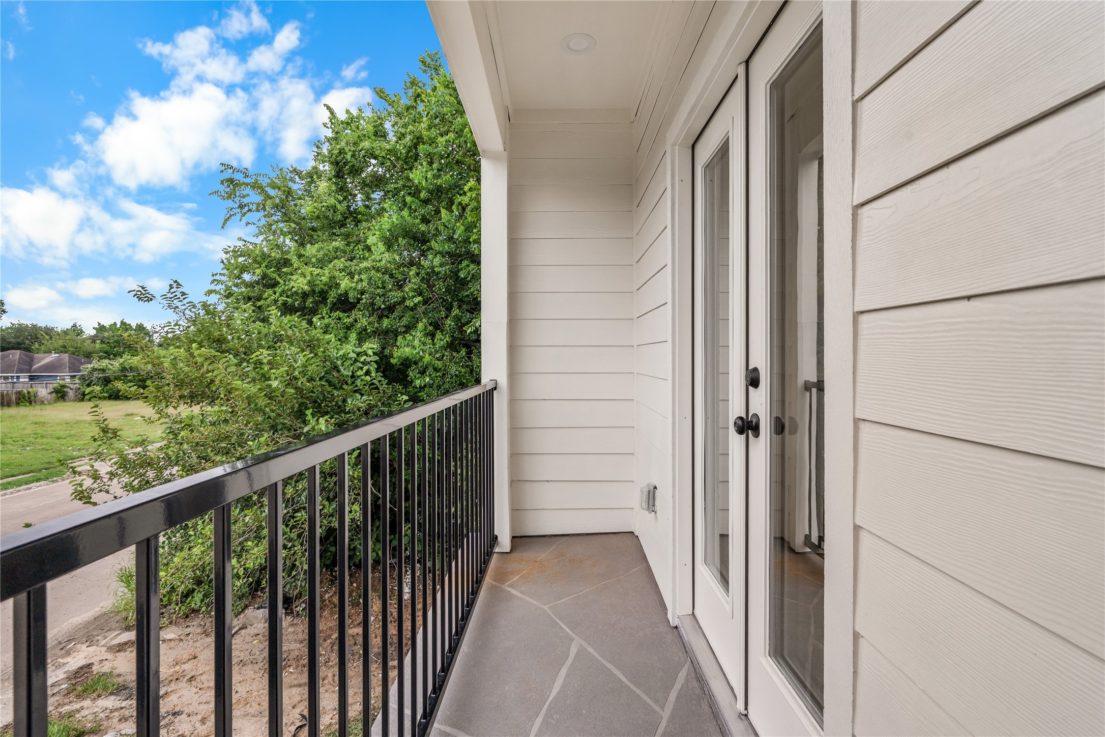3539 Mainer Street, Unit B Houston, TX 77021 - Photo 23 of 29 Private balcony off the third bedroom — iron railing, stone tile, and open sky above