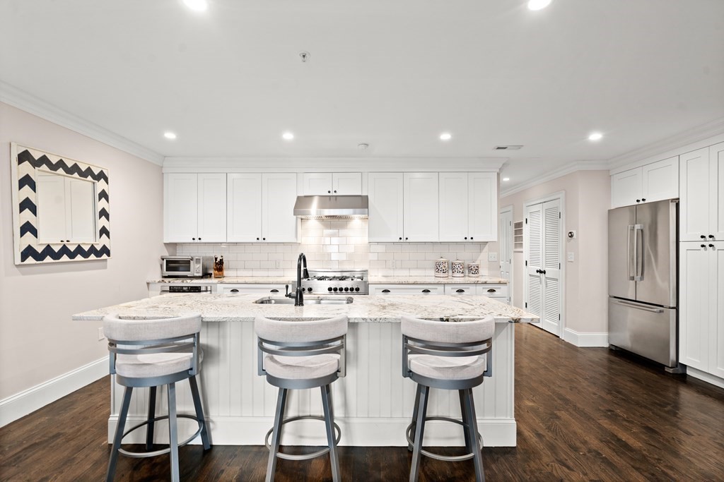 215 Athens Street, Unit 4 Boston, MA 02127 - Photo 1 of 15 a kitchen with a sink a refrigerator and white cabinets
