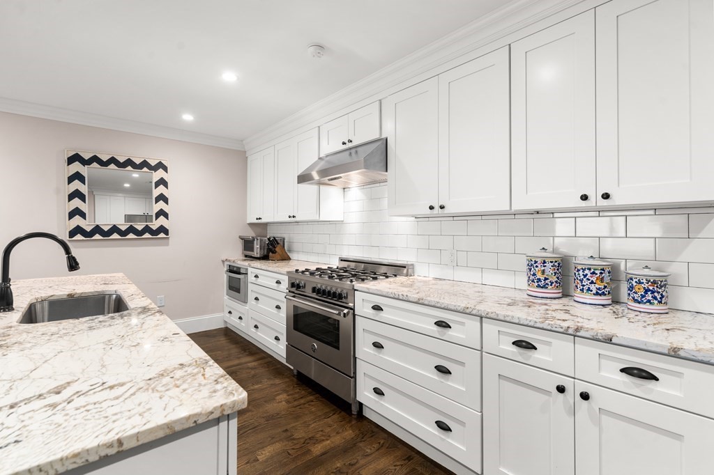 215 Athens Street, Unit 4 Boston, MA 02127 - Photo 3 of 15 a kitchen with granite countertop white cabinets and white appliances