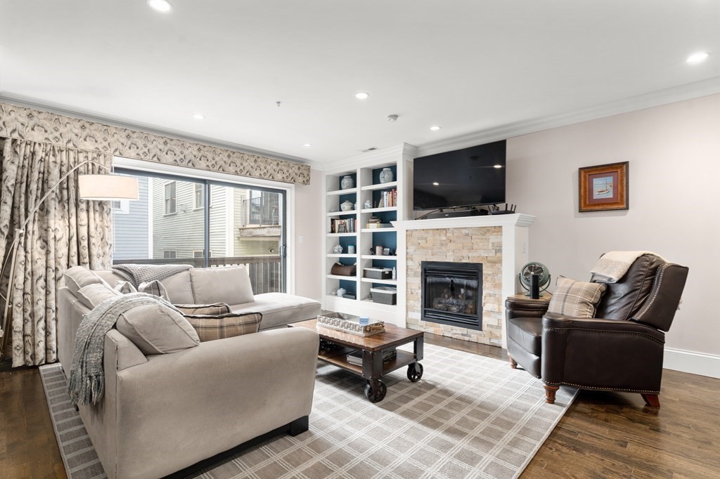 215 Athens Street, Unit 4 Boston, MA 02127 - Photo 6 of 15 a living room with furniture a flat screen tv and a fireplace