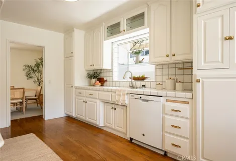 a kitchen with white cabinets and white appliances