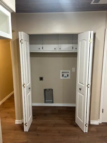a view of cabinets with stainless steel appliances wooden floor and window