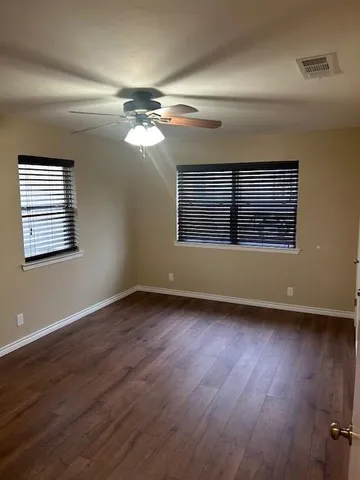 a view of a livingroom with wooden floor and a ceiling fan