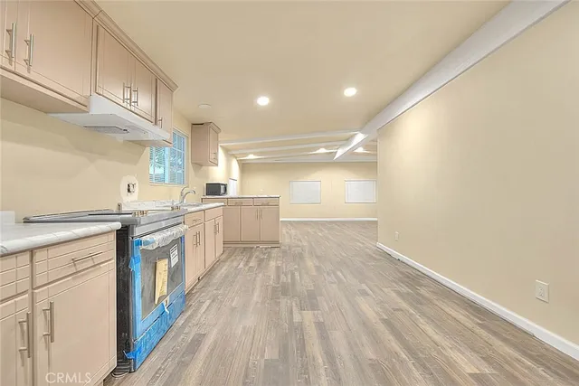 a large kitchen with a lot of counter space and wooden floor