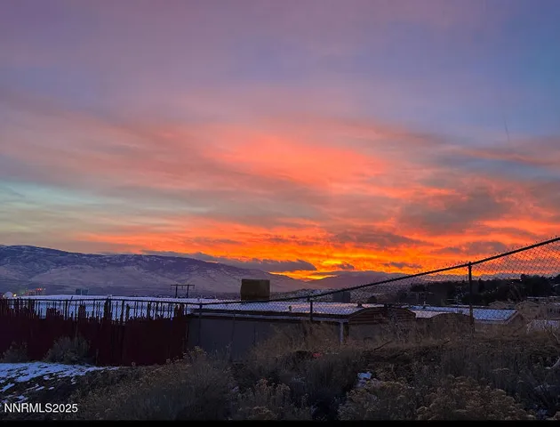 a view of a lake with sunset in background