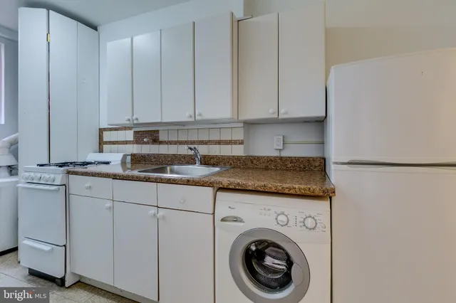 a kitchen with granite countertop white cabinets and sink