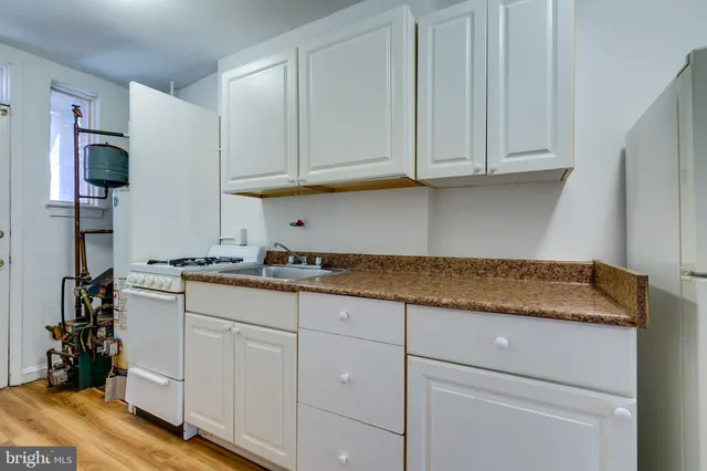 a kitchen with granite countertop white cabinets and sink